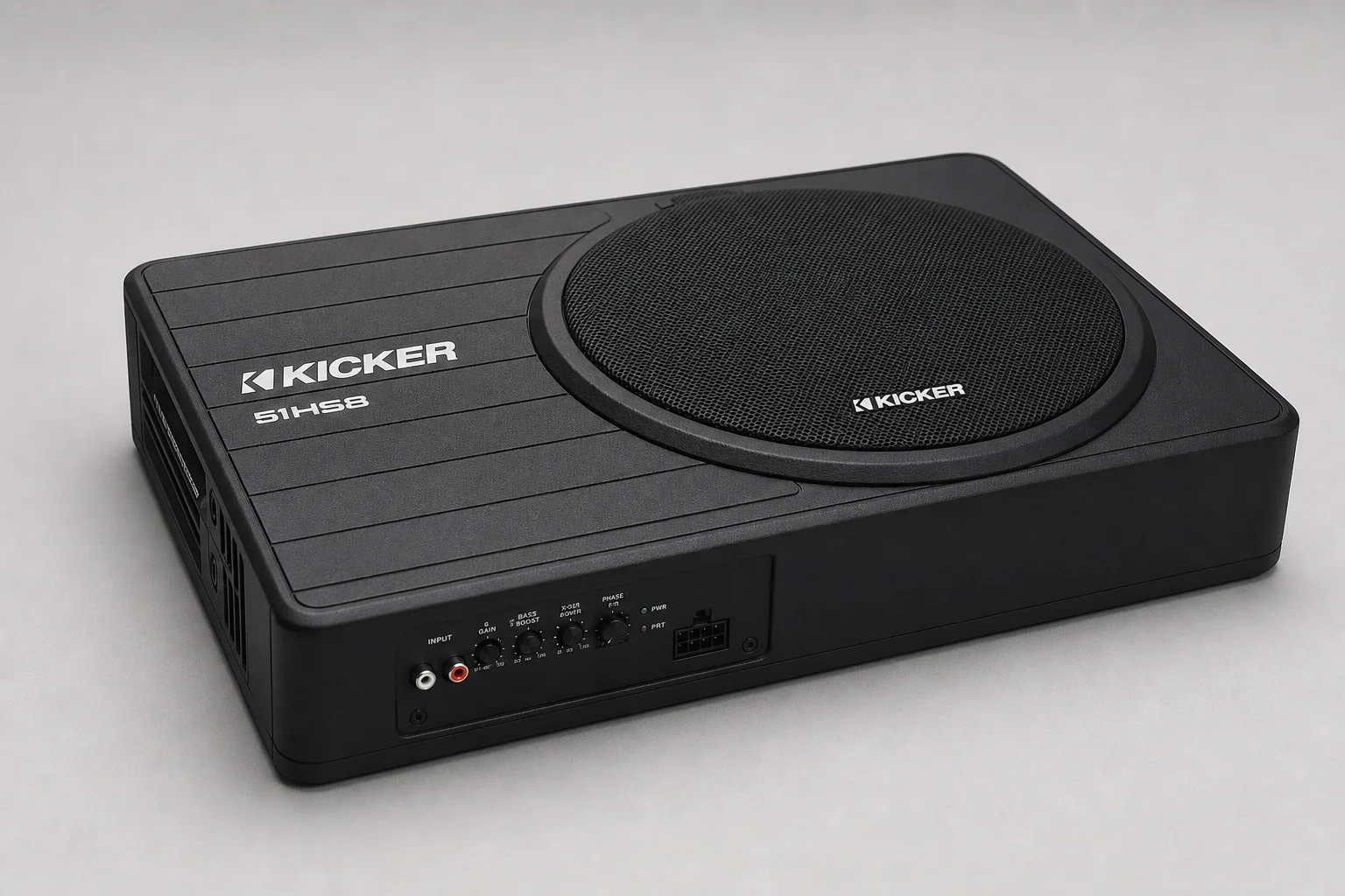 Seven car powered subwoofers of varying sizes arranged on grey surface