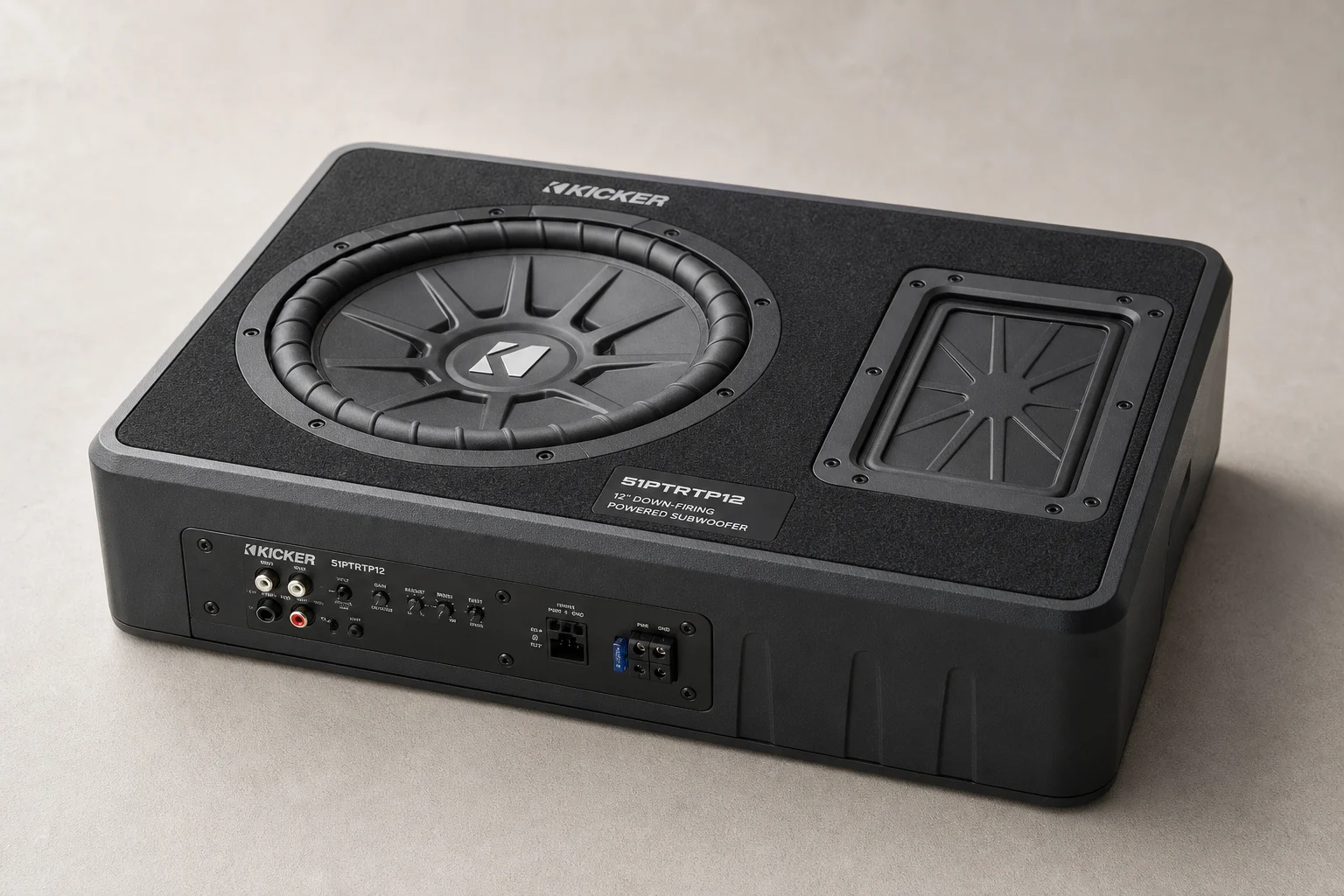 Seven car powered subwoofers of varying sizes arranged on grey surface