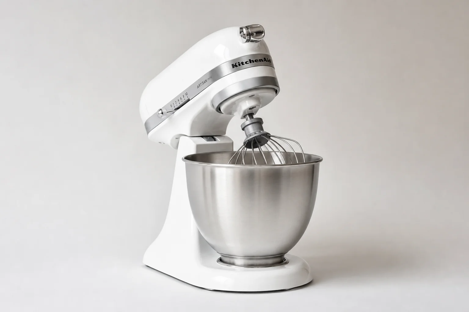 Four stand mixers in different sizes and styles arranged on a neutral backdrop