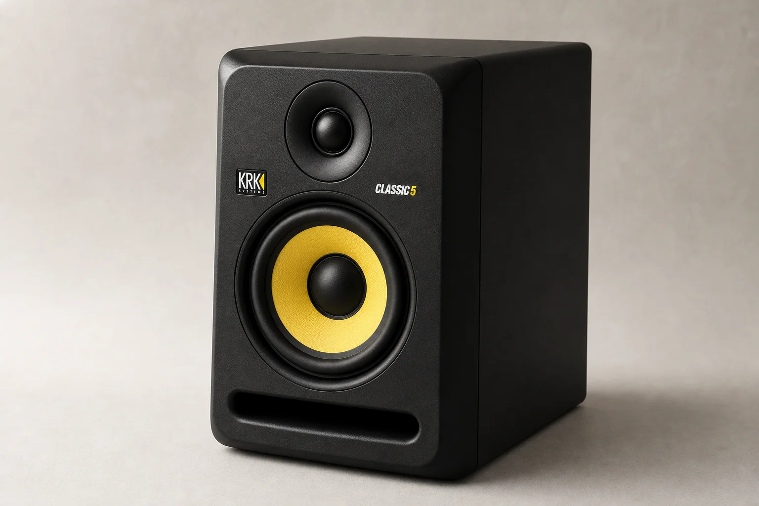 Five studio monitors arranged on concrete surface showing different sizes and designs