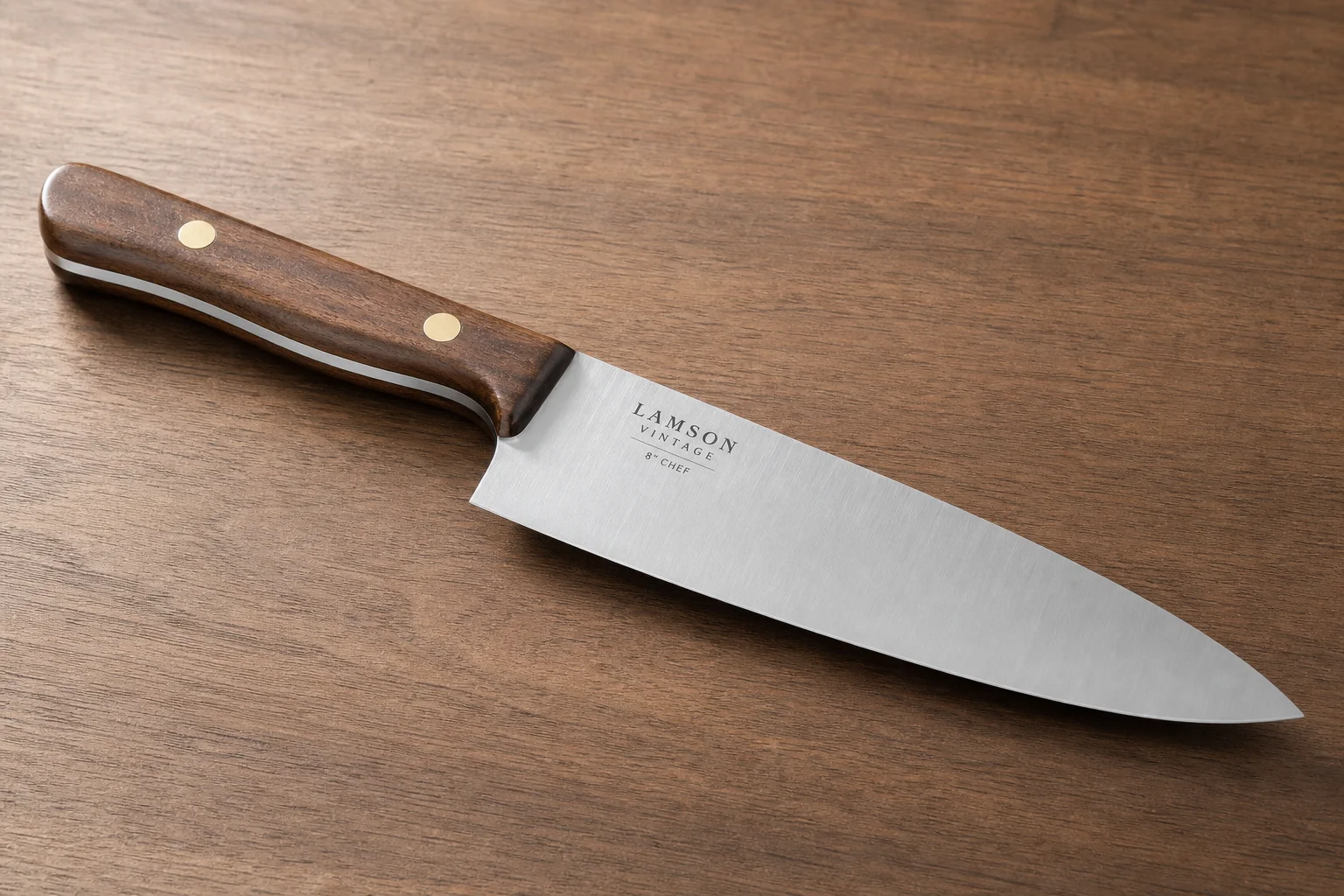 Collection of eight chef's knives with varied styles and handle materials arranged diagonally on concrete