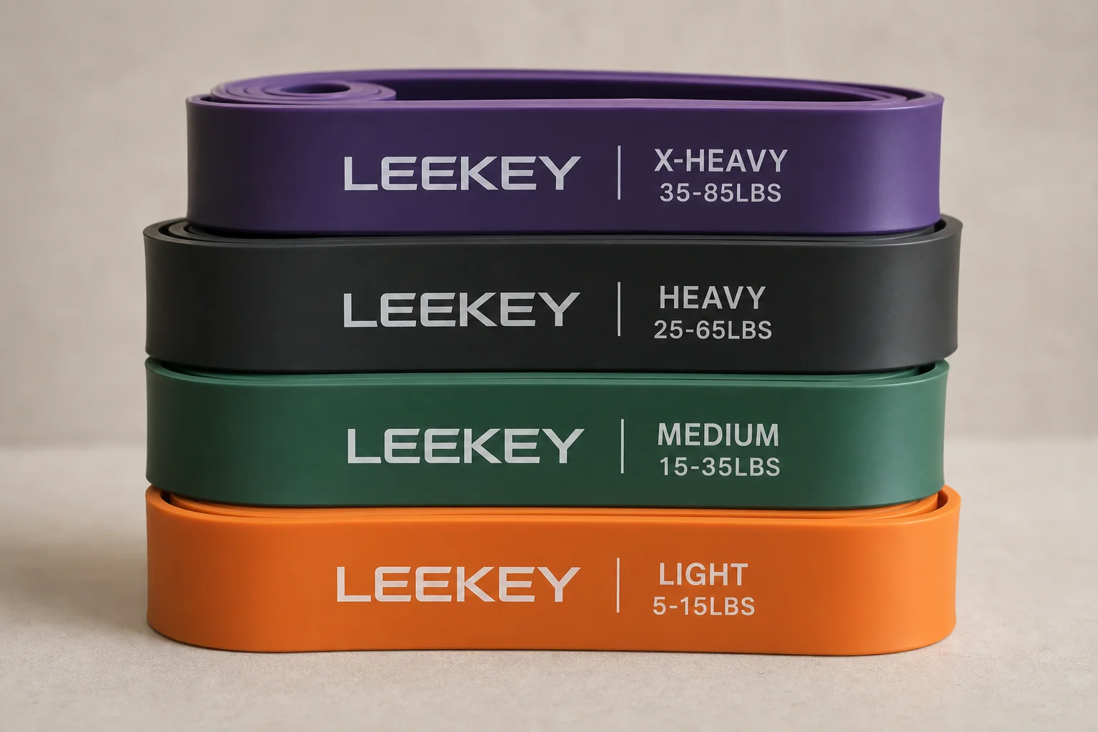 Five resistance band sets displayed on concrete surface showing different styles and colors