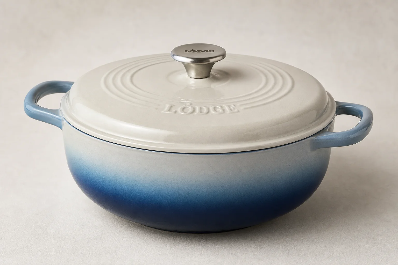 Collection of nine Dutch ovens in various colors and finishes arranged on neutral backdrop