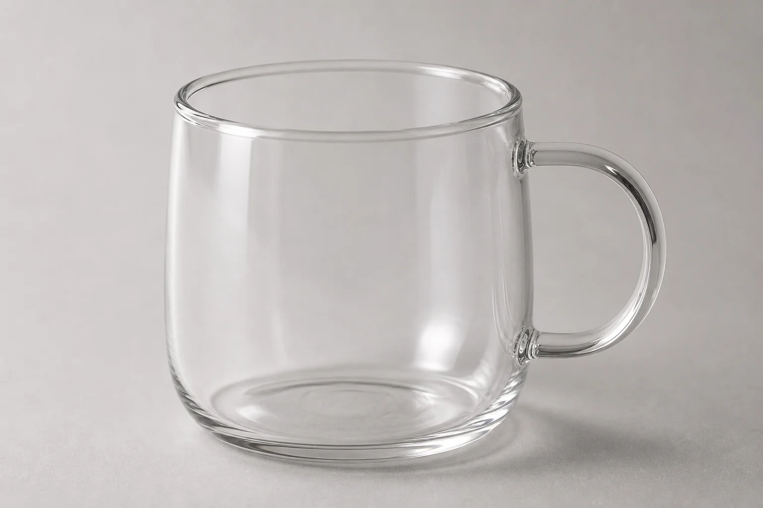 Four non-toxic coffee mugs in glass, ceramic, and stainless steel arranged on concrete