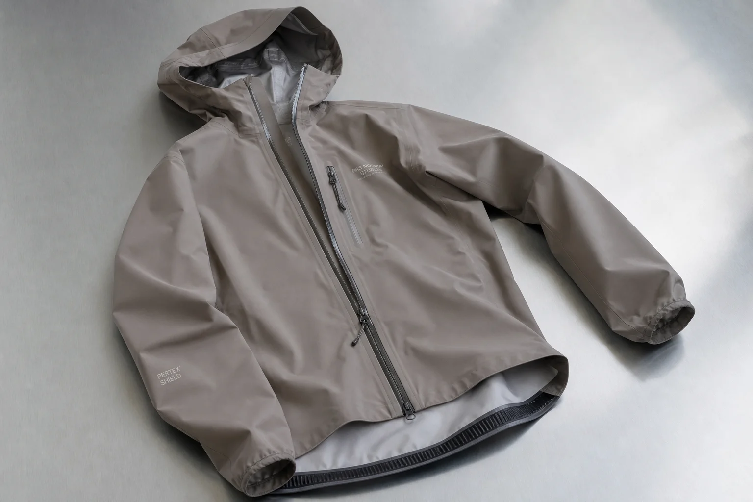 Five cycling rain jackets in various colors arranged on neutral backdrop