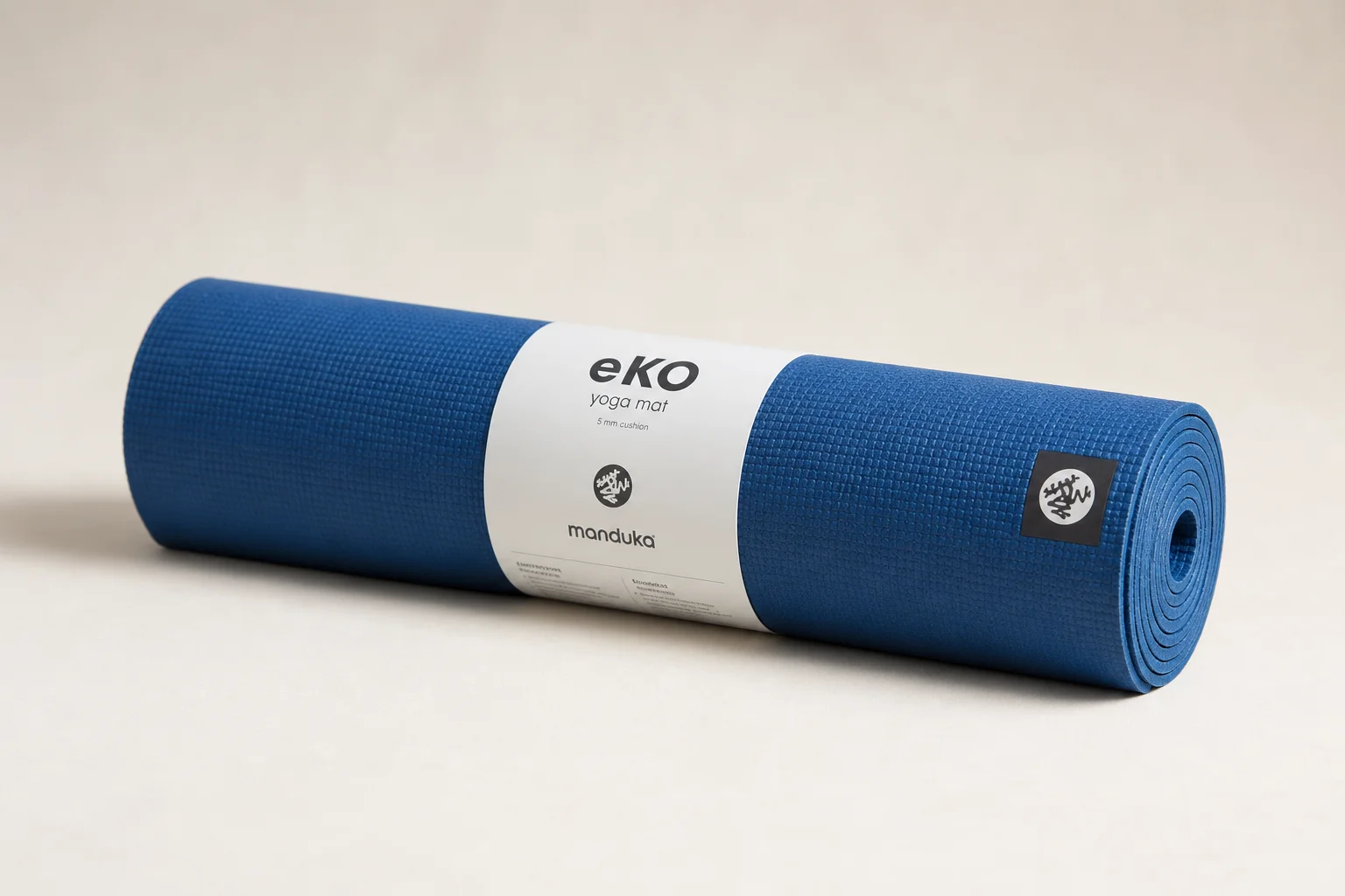 Four different pilates and yoga mats arranged on a wooden floor