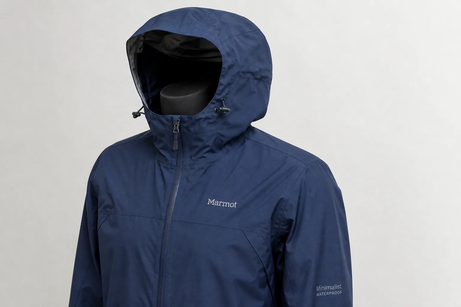 Five waterproof jackets in different colors and styles arranged on concrete