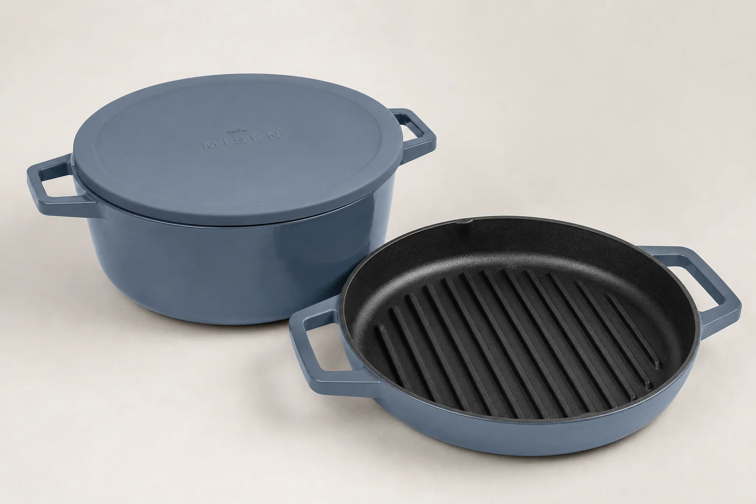 Collection of nine Dutch ovens in various colors and finishes arranged on neutral backdrop