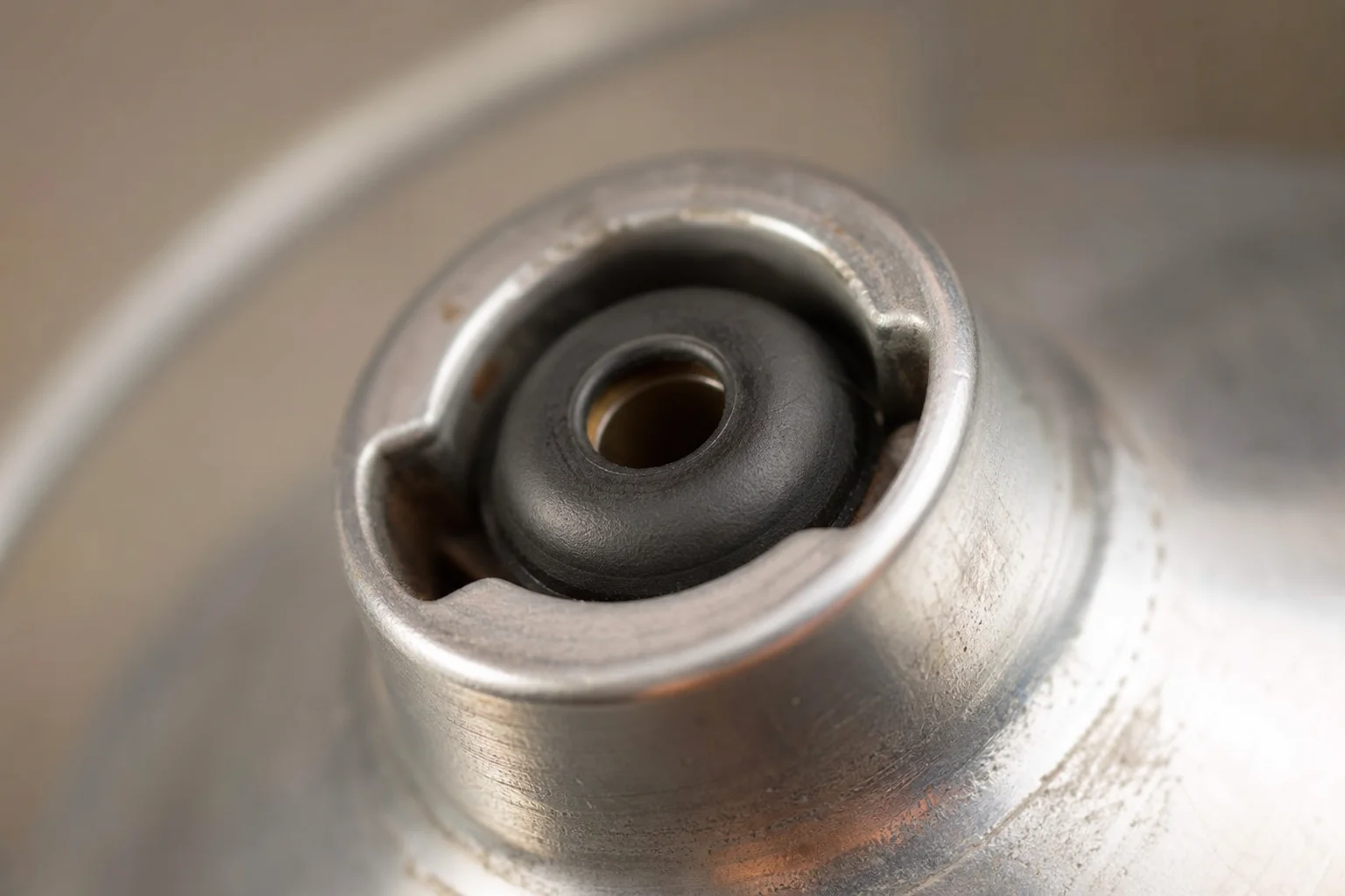 Close-up of moka pot pressure valve mechanism showing internal rubber valve