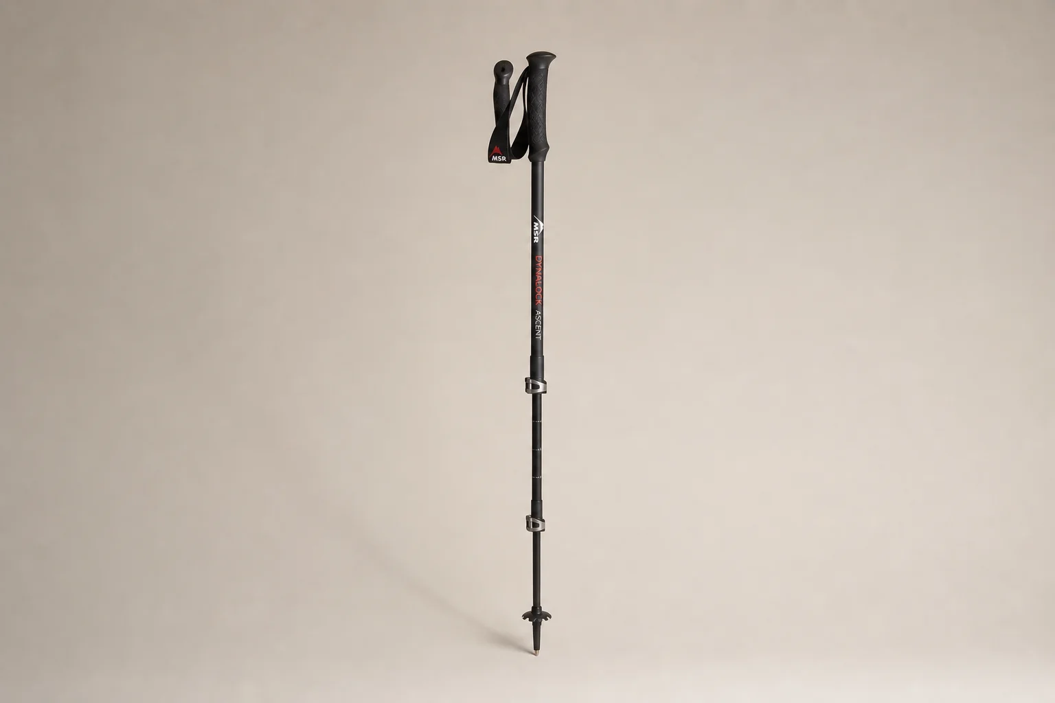 Five hiking poles arranged in a fan pattern on concrete surface