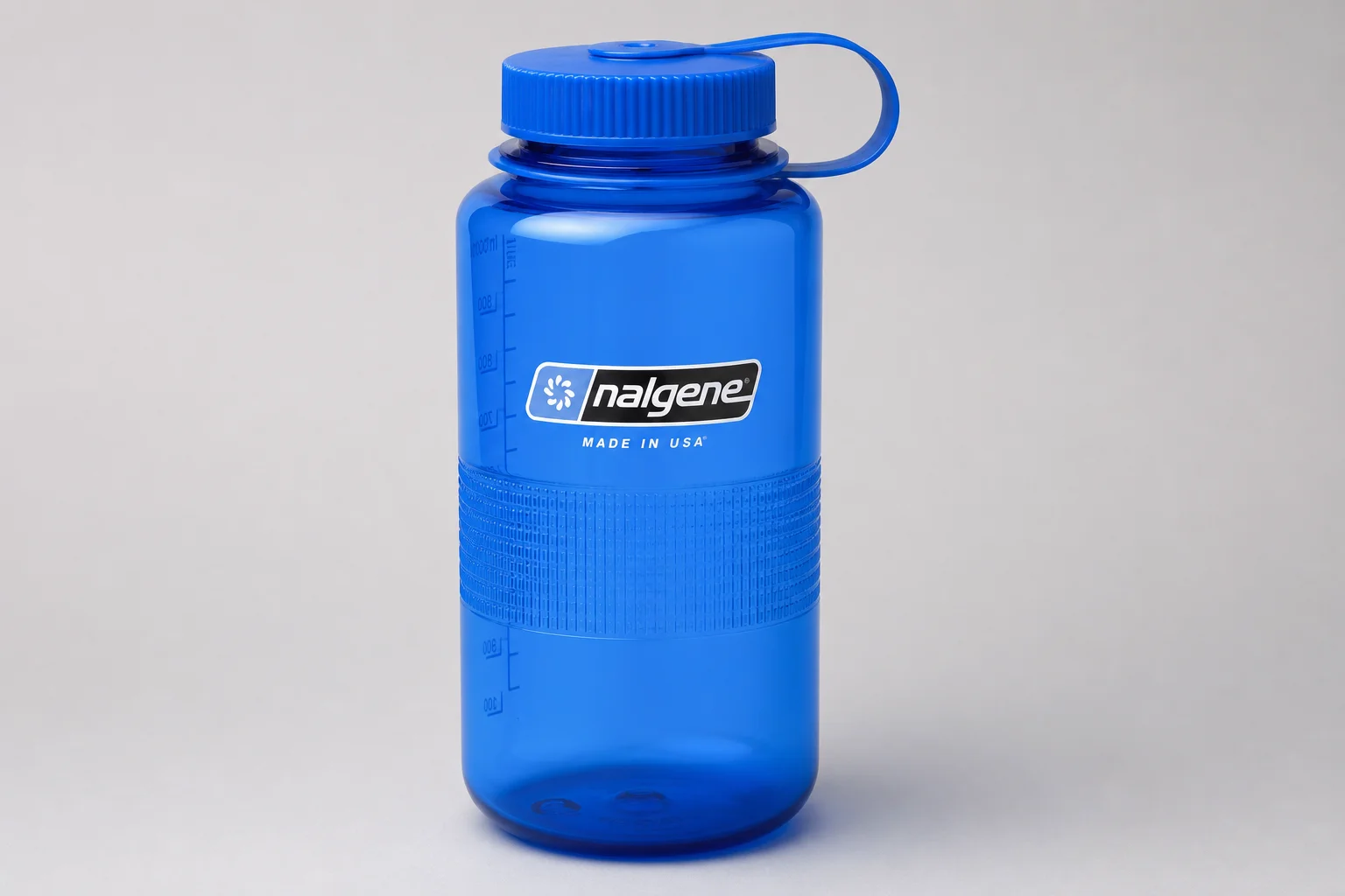 Three water bottles: Nalgene plastic, Klean Kanteen stainless steel, and Hydro Flask insulated on concrete