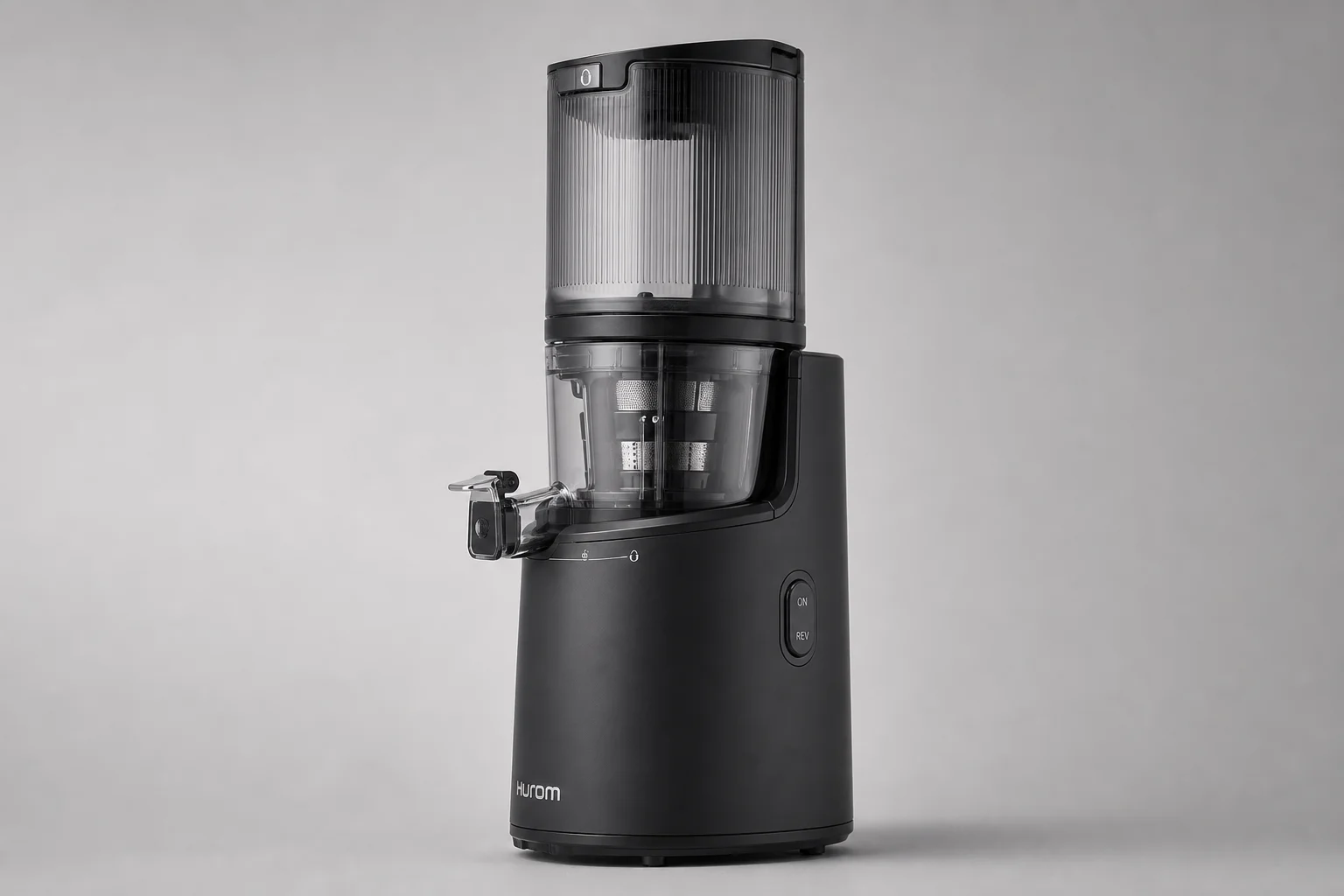 Four cold-press juicers arranged on concrete surface showing different sizes and designs