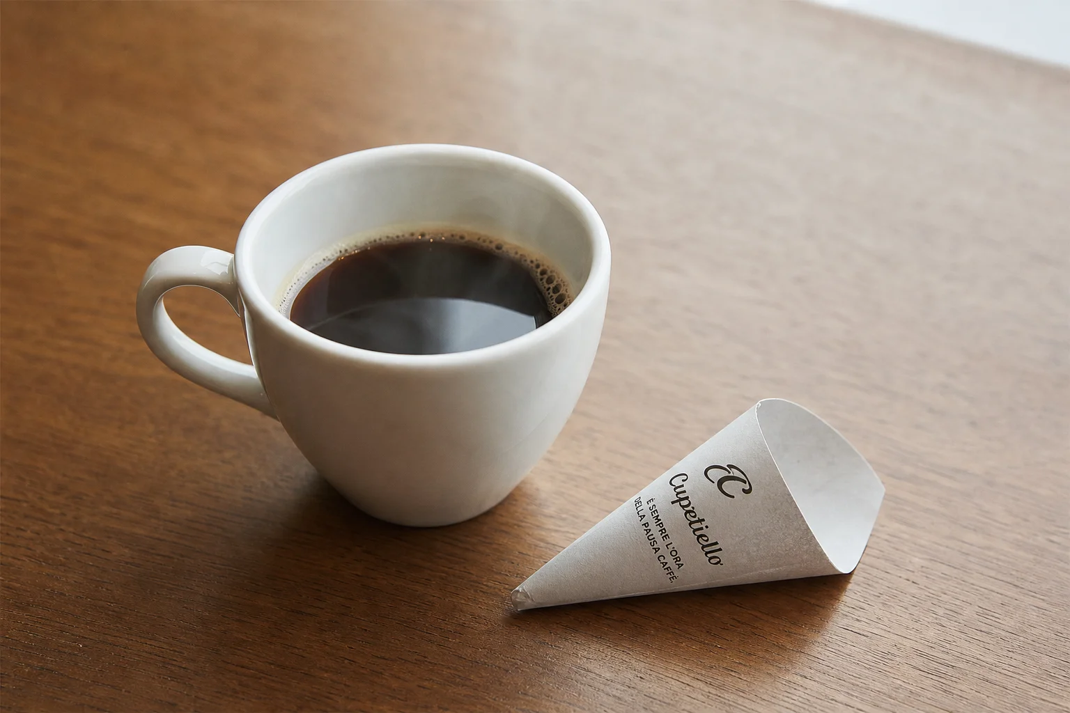 Finished cup of coffee with small paper cone cuppetiello on wooden table