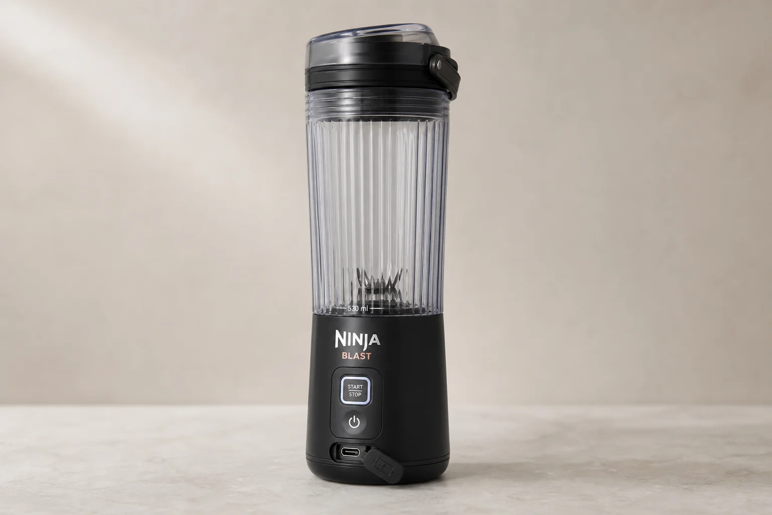 三款便攜式果汁機並排放在水泥地上：Ninja Blast、NutriBullet 與 Fridja