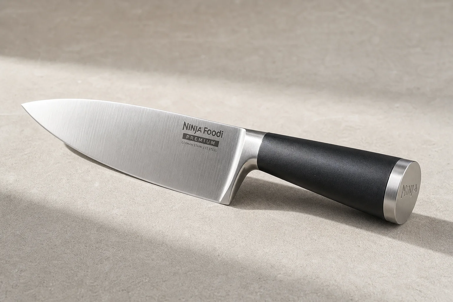 Collection of eight chef's knives arranged diagonally on concrete surface showing various styles and price points