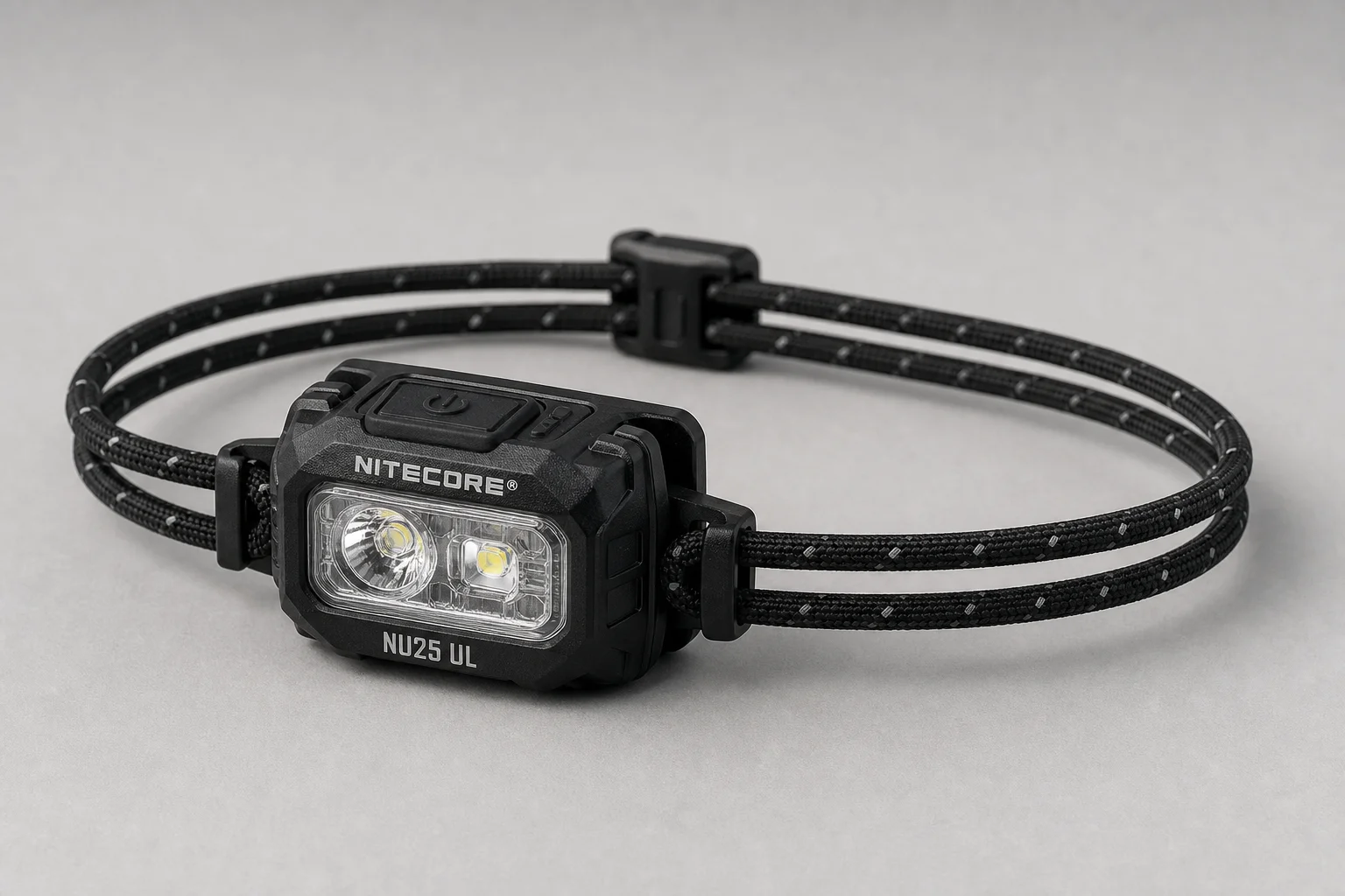 放置於水泥地面的 Nitecore UT27 與 NU25 UL 頭燈