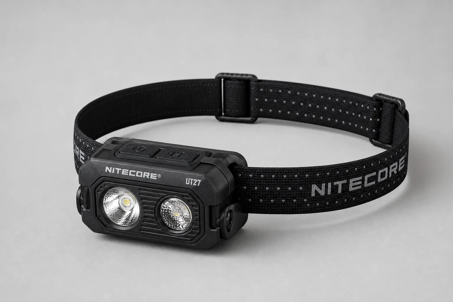 Nitecore UT27 與 NU25 UL 頭燈放置於水泥地面上