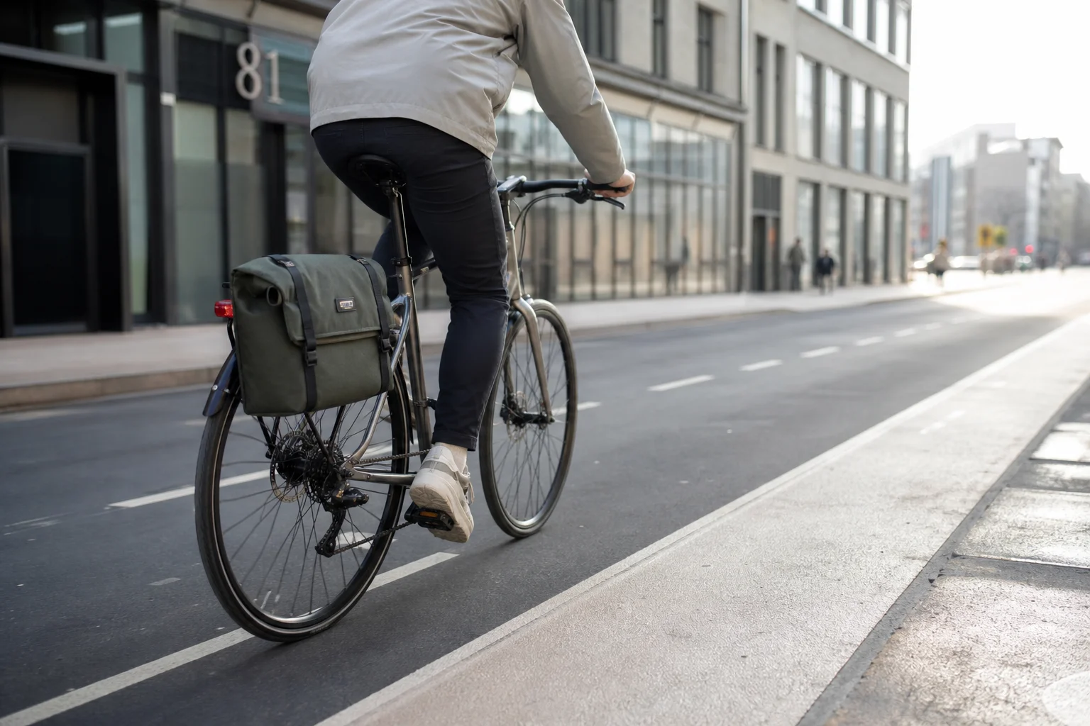 Cyclist commuting on urban street with pannier mounted on rear rack