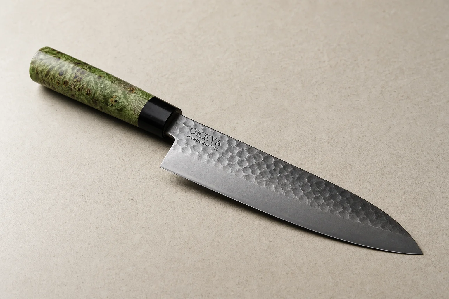 Collection of eight chef's knives arranged diagonally on concrete surface showing various styles and price points