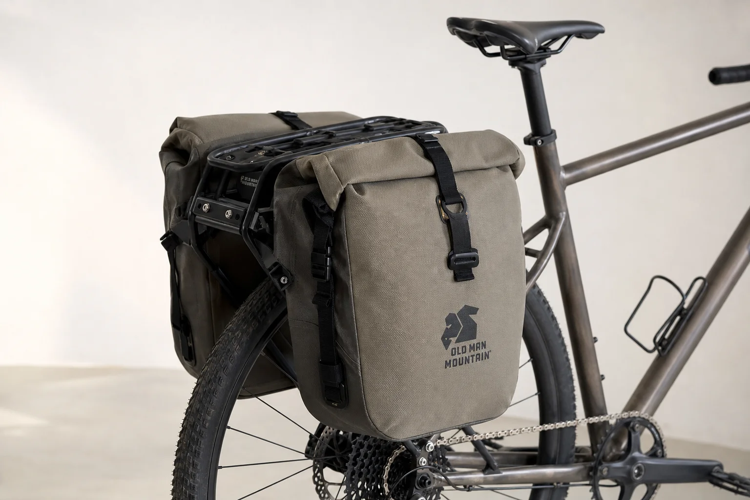 Fully loaded trail bike with Old Man Mountain racks and bags on neutral backdrop