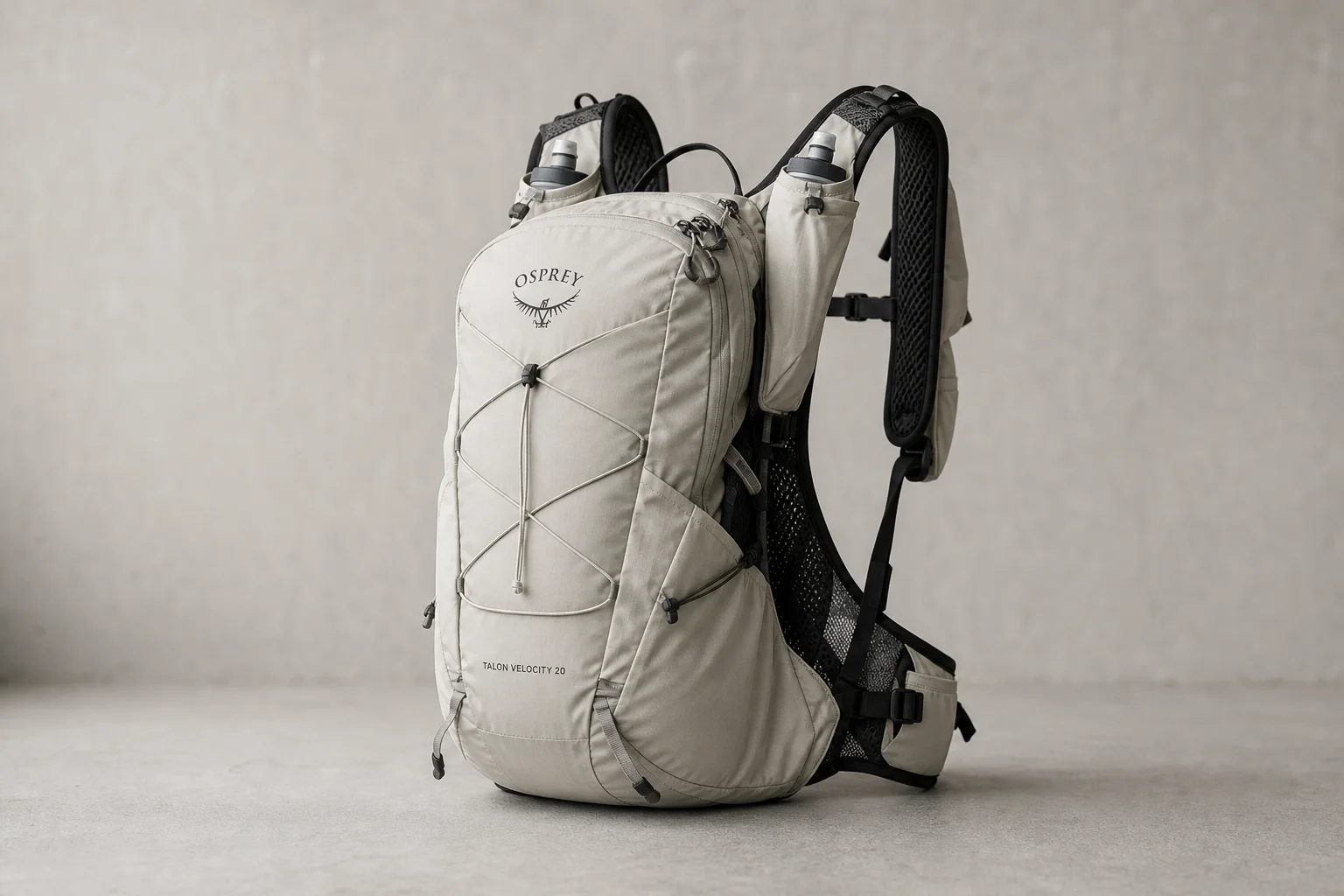 Osprey Talon Velocity 20 backpack displayed on concrete surface showing front pockets and shoulder straps