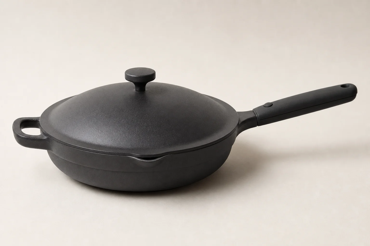 Five cast iron skillets arranged on a wooden surface showing different styles and finishes