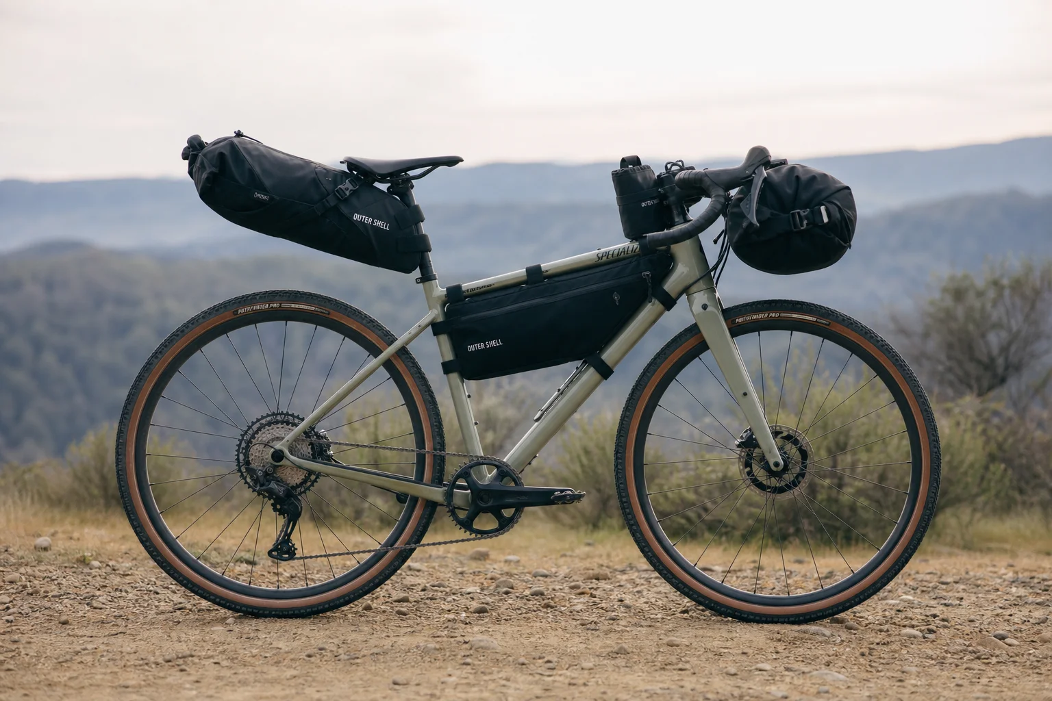 Cyclist on gravel bike loaded with multiple Outer Shell bags ready for bikepacking