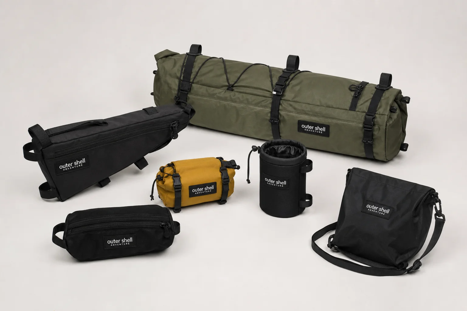 Six Outer Shell bike packing bags in various colors and sizes on neutral backdrop