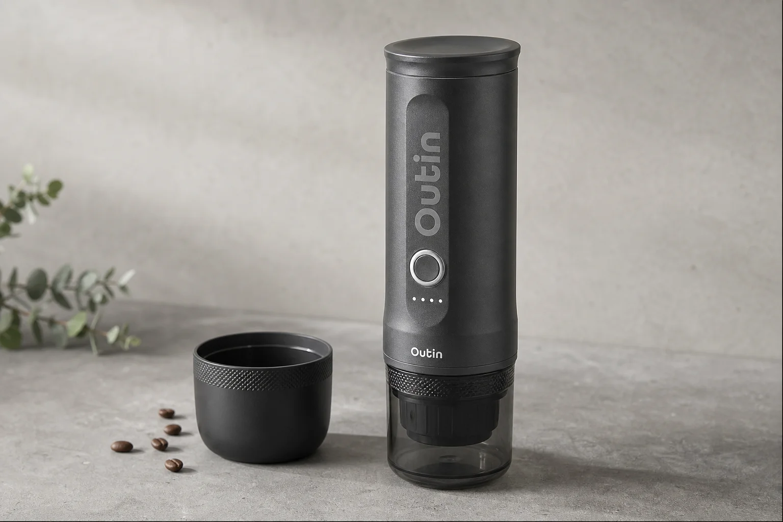 Outin Nano portable espresso maker on concrete surface with cup and accessories