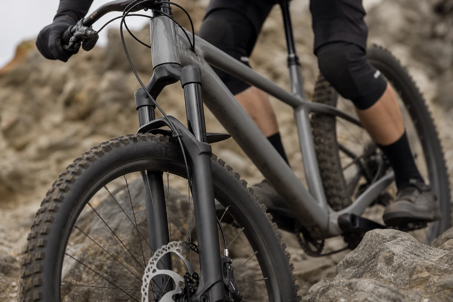 Close-up of suspension fork and hydraulic disc brake on rocky descent