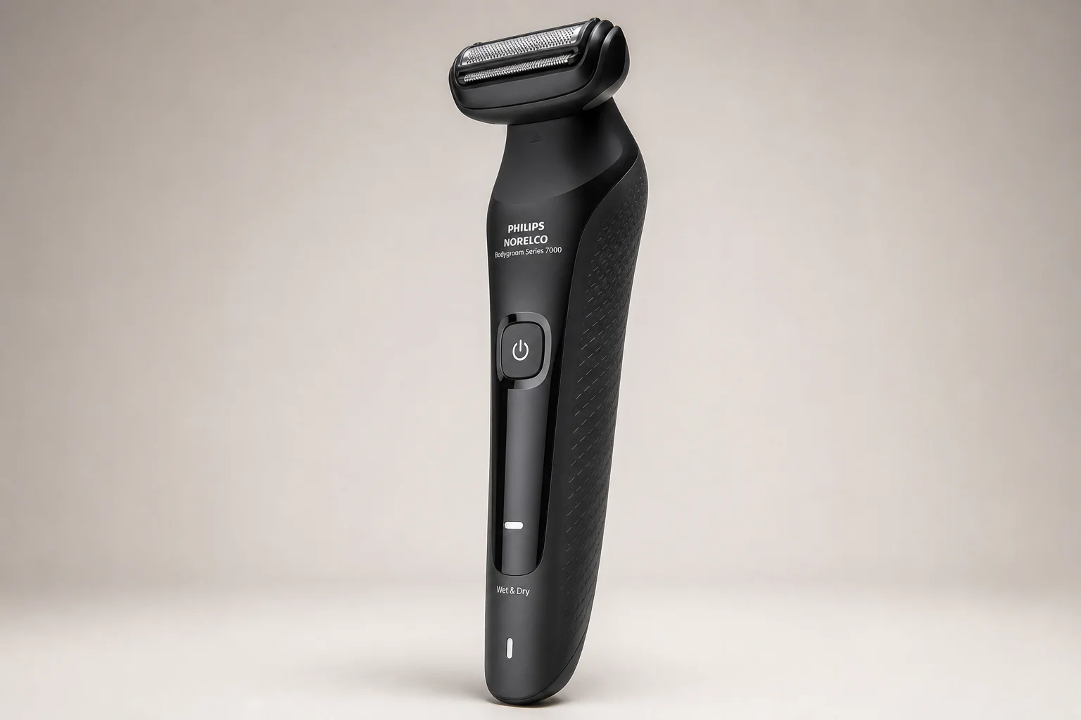 Six pubic hair trimmers arranged on grey surface showing various designs and attachments