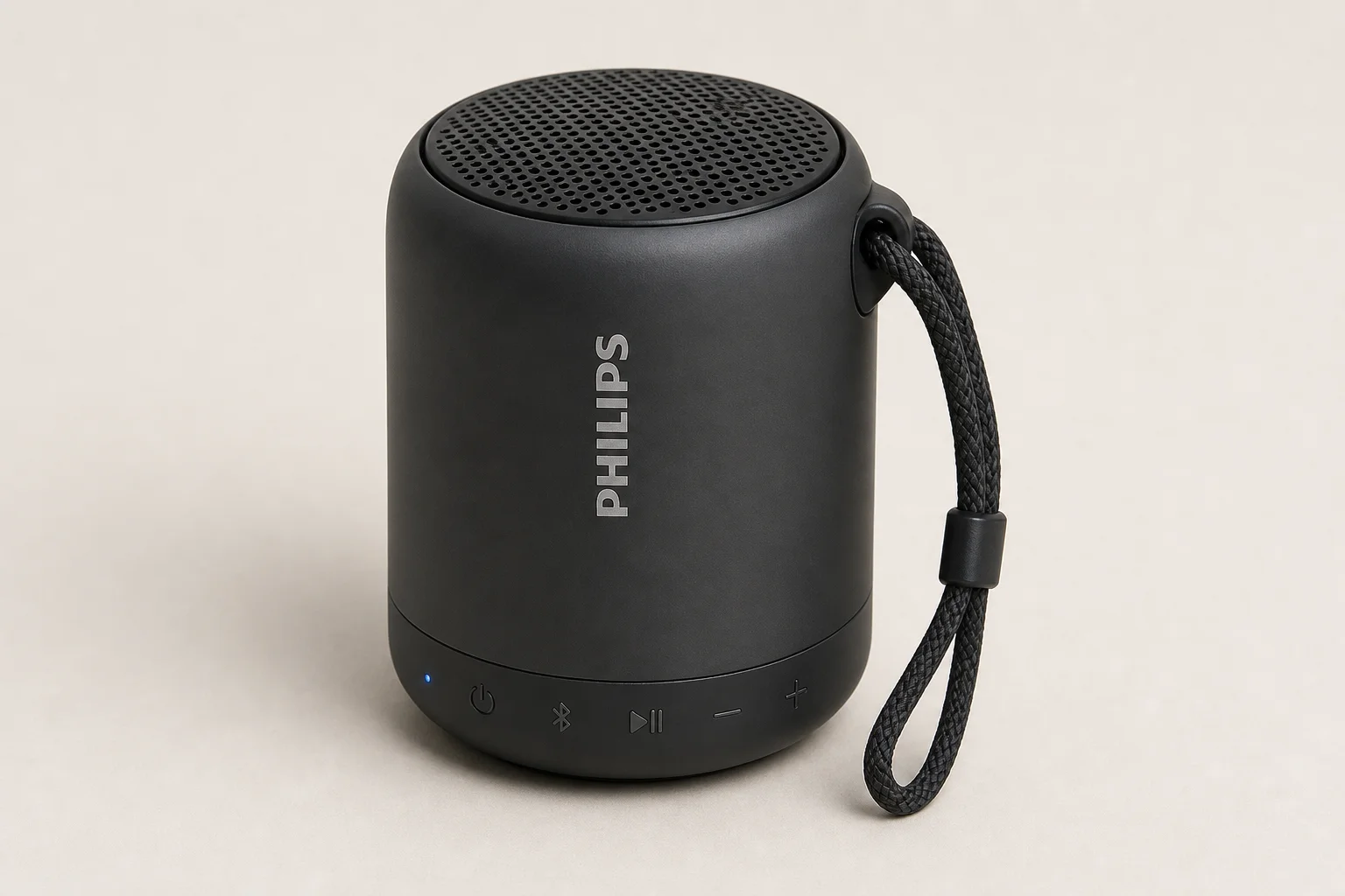 Five budget Bluetooth speakers arranged on concrete surface