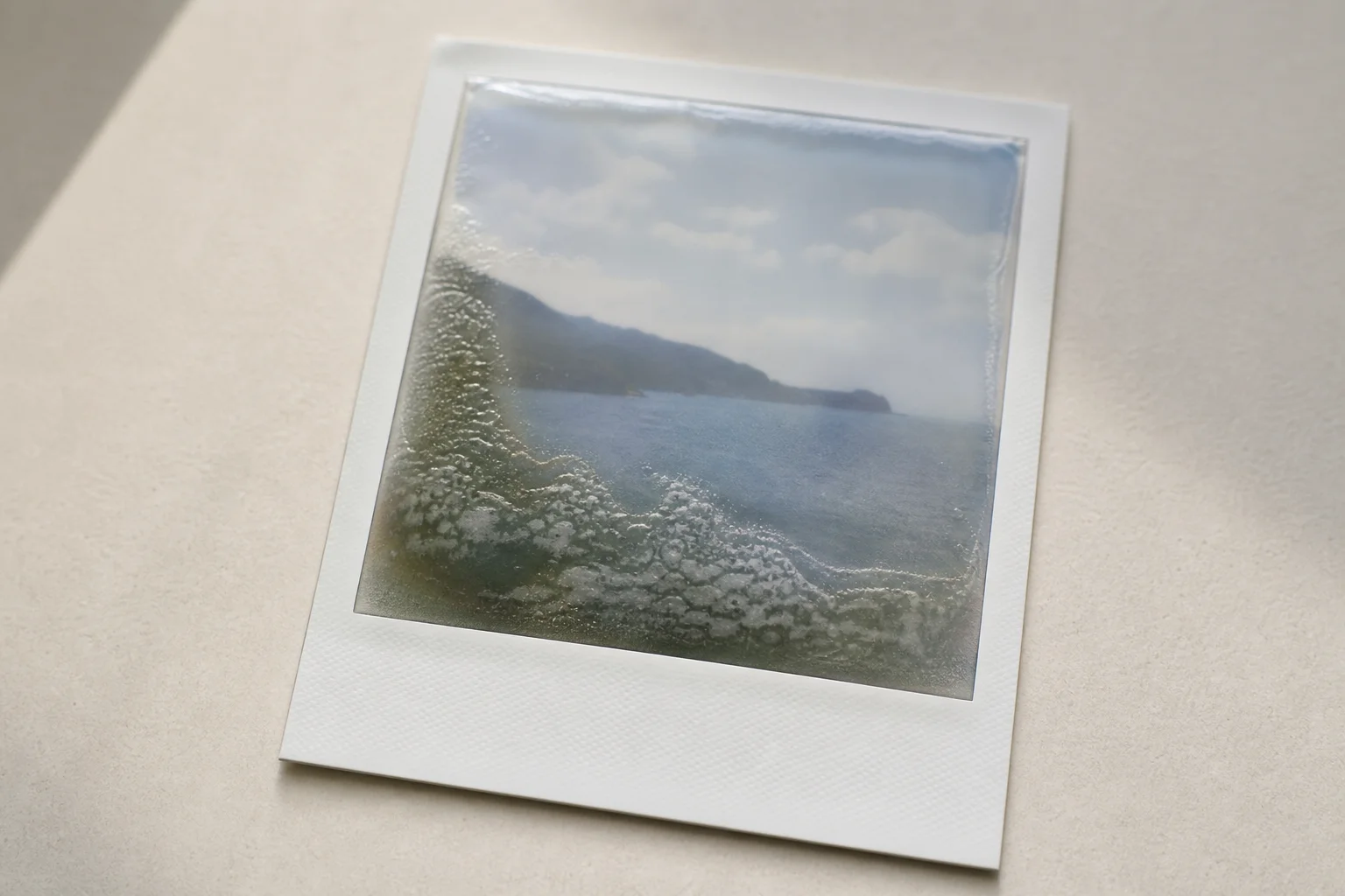 Instant film photograph developing on a neutral surface with characteristic Polaroid white border