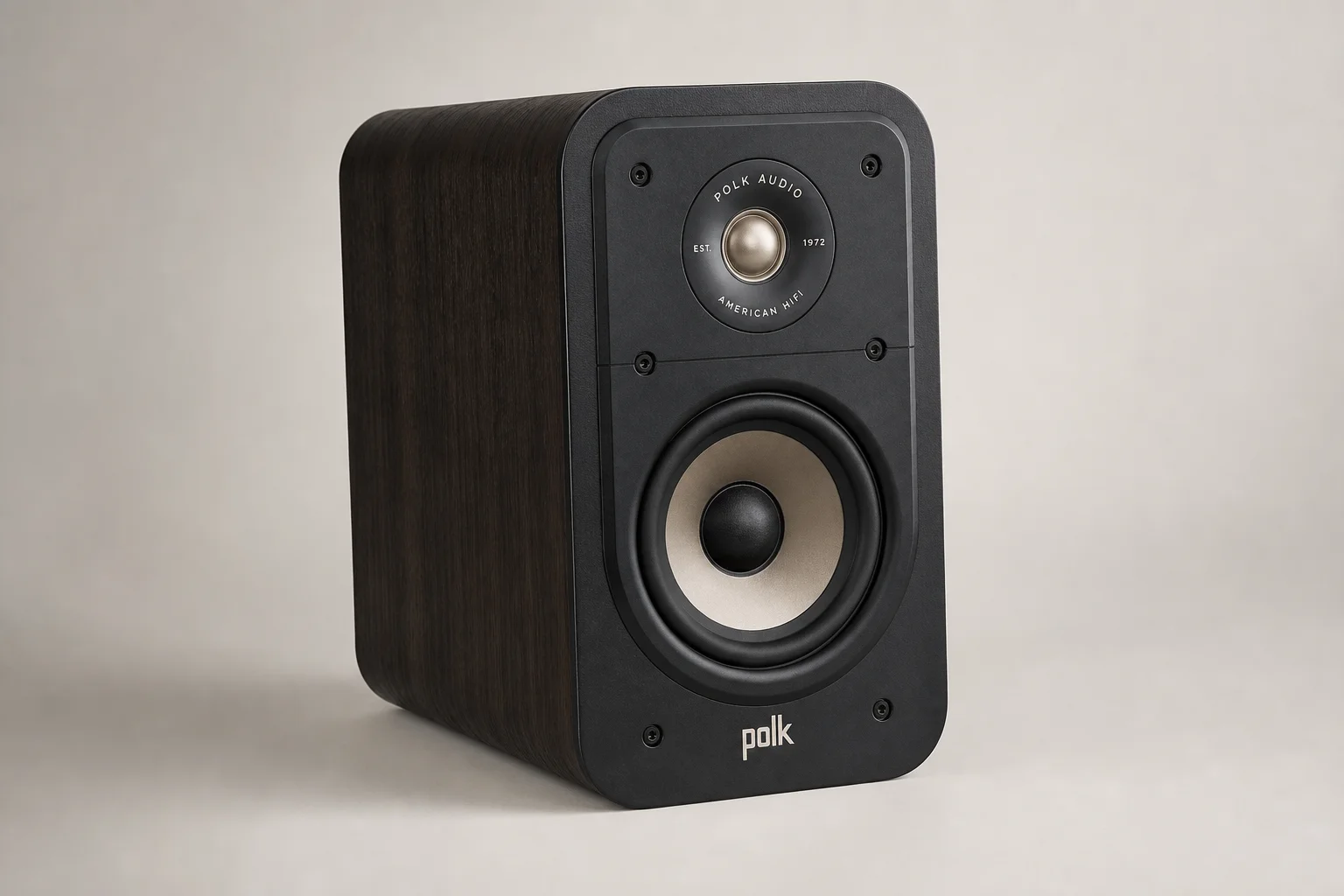 Six bookshelf speakers in varying sizes and finishes arranged on concrete surface