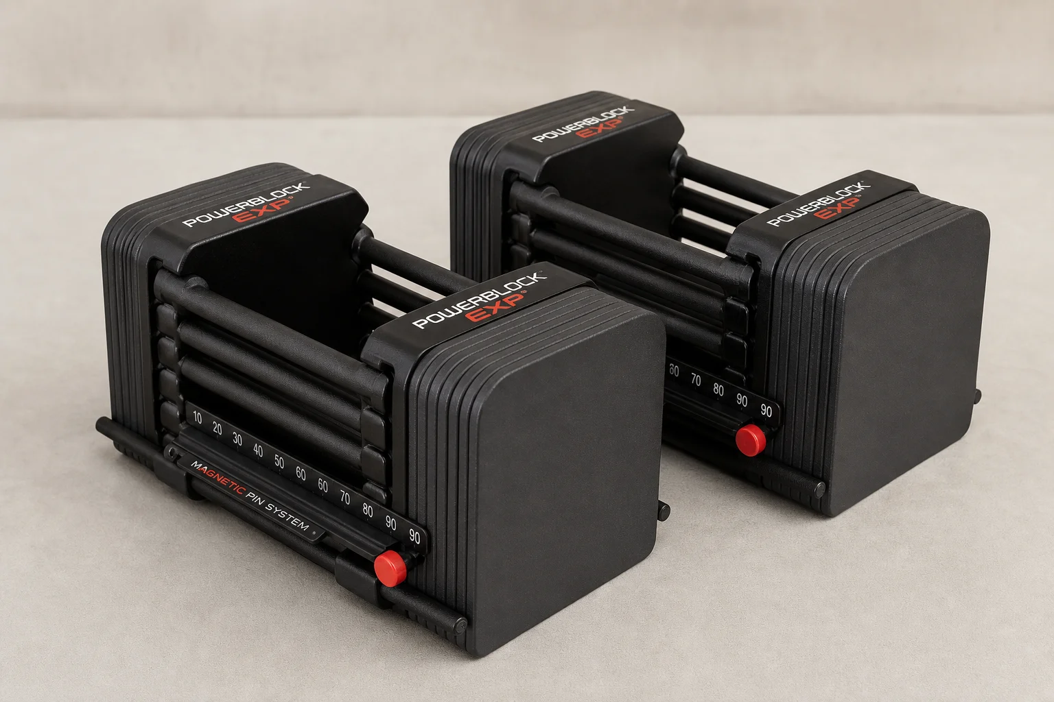 Seven different adjustable dumbbell models arranged on concrete surface