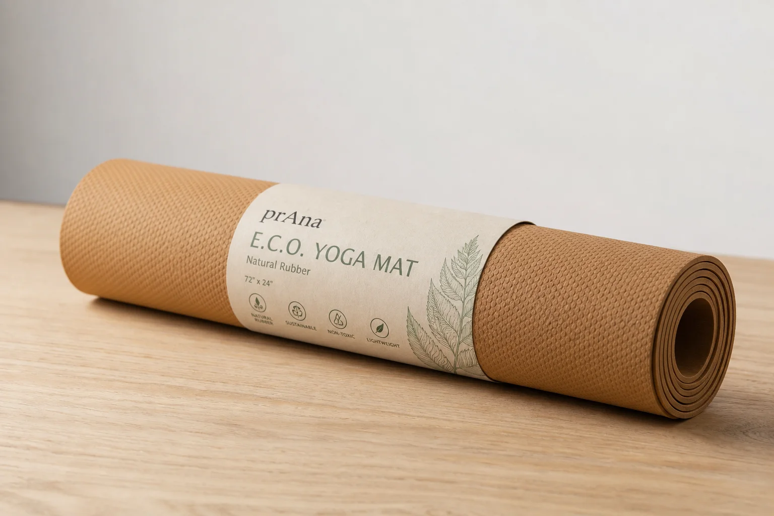 Seven different yoga mats arranged on a wooden floor showing variety of styles and colors