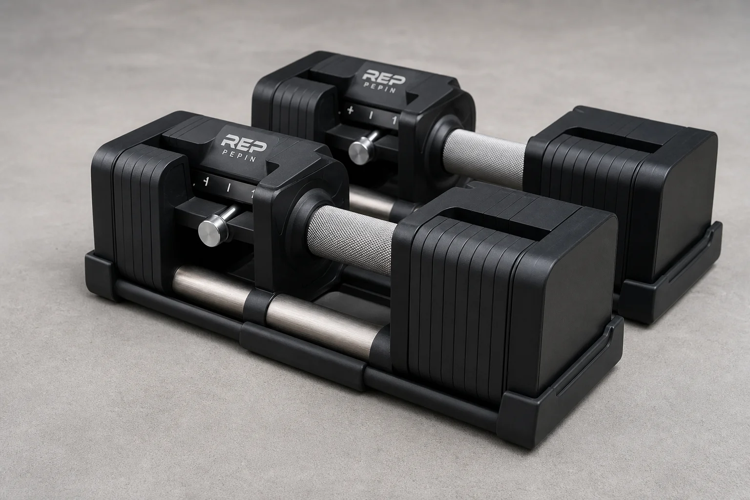 Seven different adjustable dumbbell models arranged on concrete surface