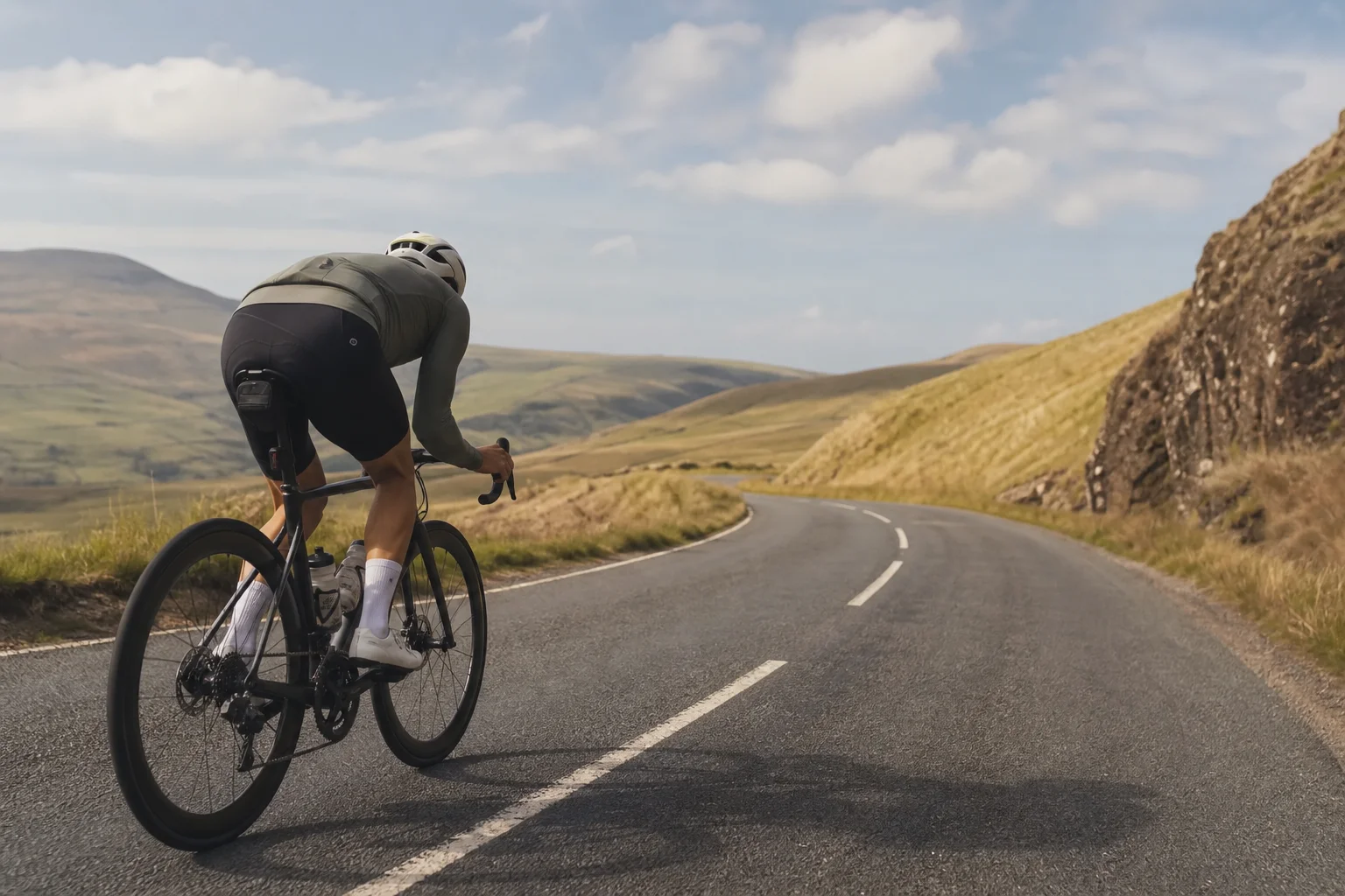 Road cyclist riding on smooth tarmac in aerodynamic position