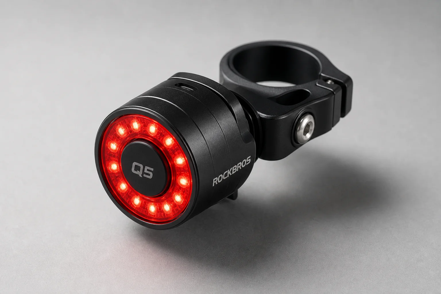 RockBros Q5 rear bike light mounted on aluminum clamp on grey surface
