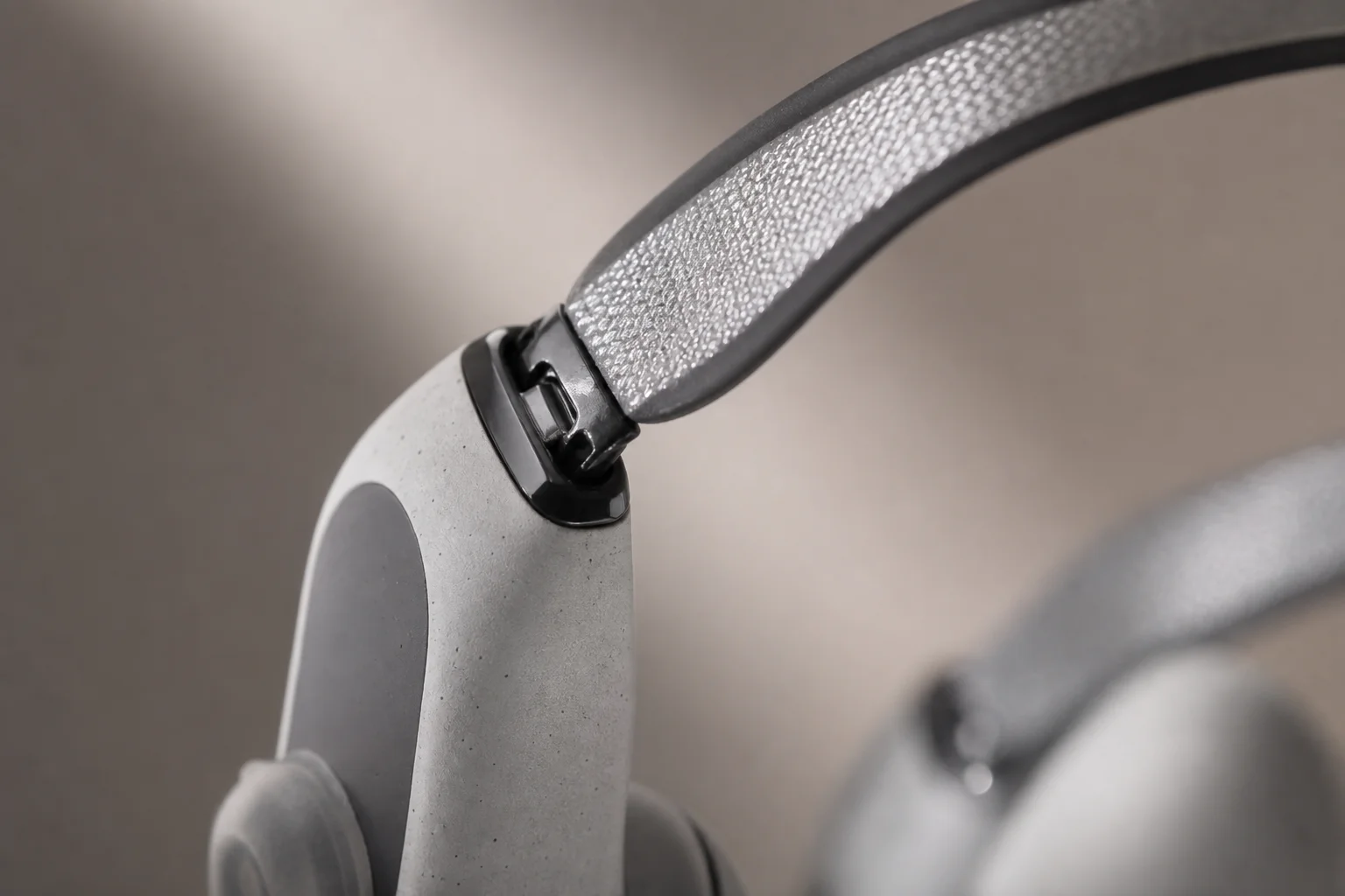 Close-up of detachable reflective neckband attachment on earbud