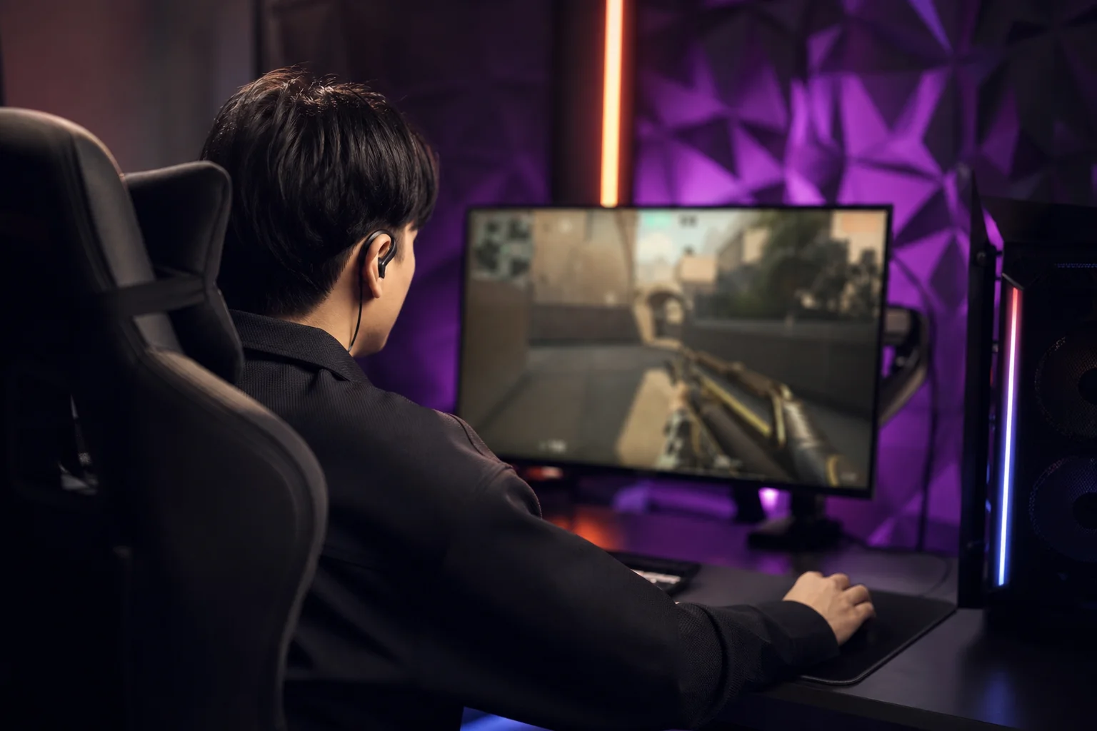 Esports player in competitive gaming environment wearing open-back earbuds