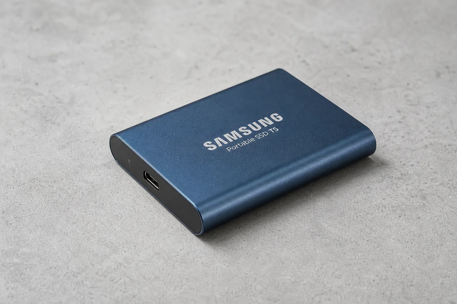 五款外接式 SSD 排列在混凝土表面上，展示了不同的外型規格與設計。