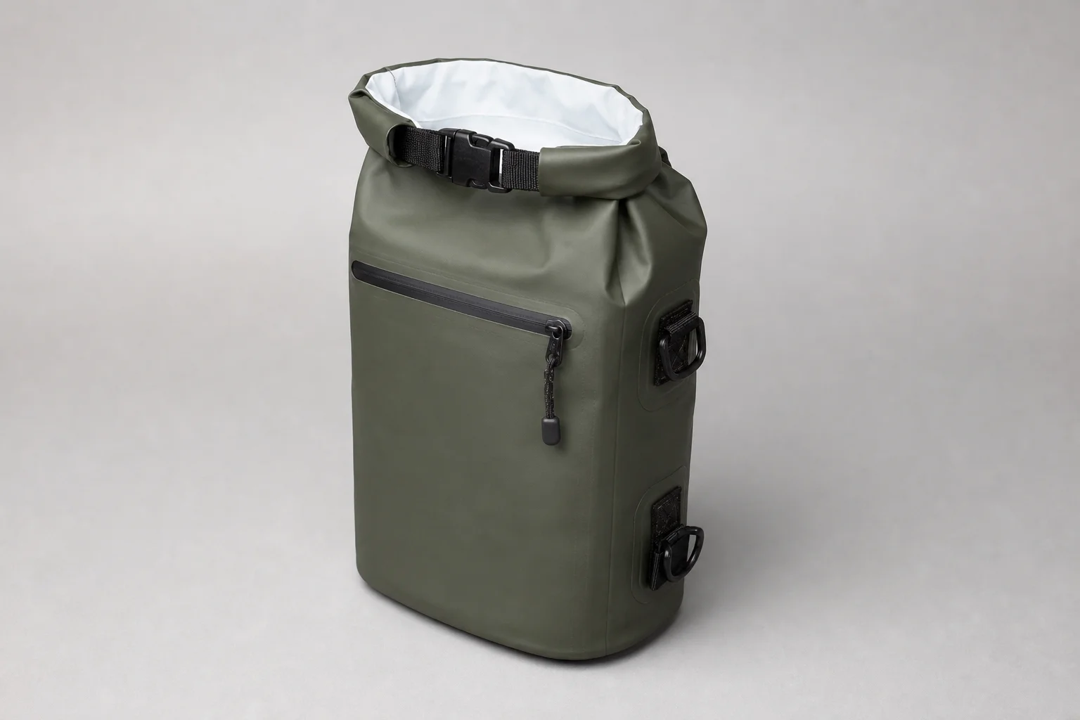 Five waterproof dry bags in various sizes and colors arranged on concrete