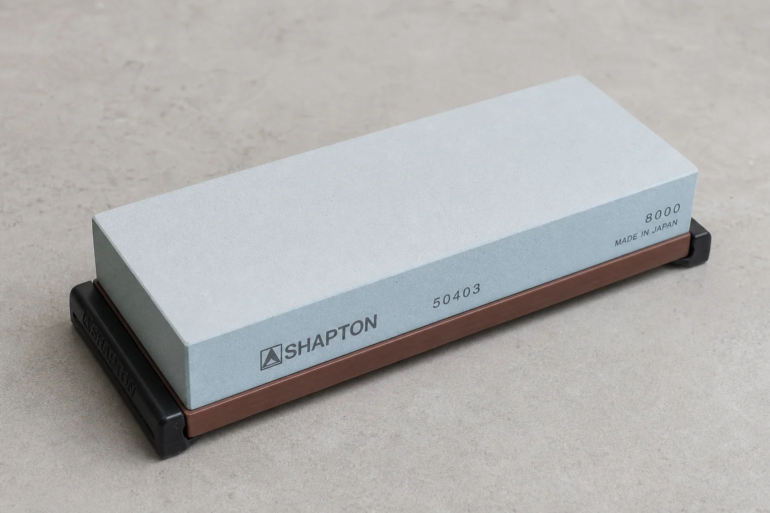 Five different knife sharpeners arranged on concrete surface