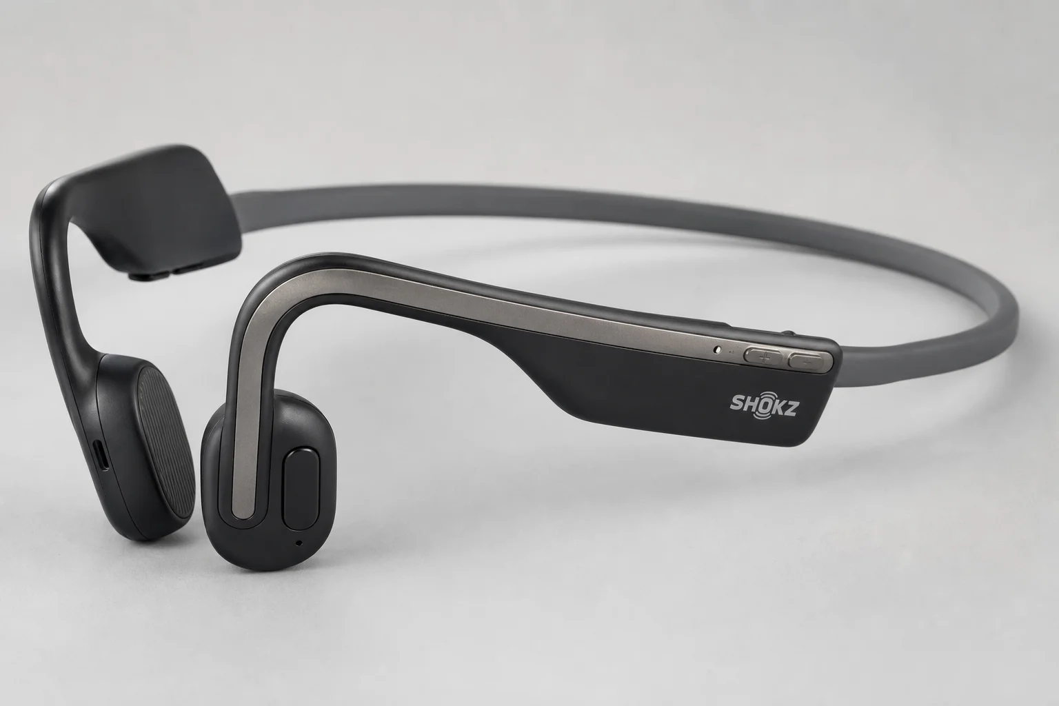Sanag A5X and Shokz OpenMove bone conduction headphones on concrete surface