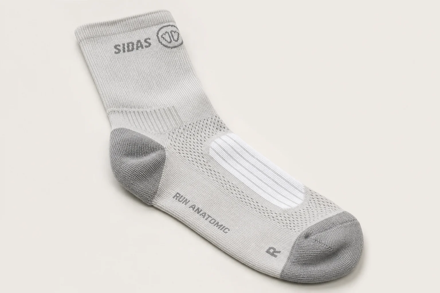 Collection of running socks in various colors and styles arranged on concrete surface
