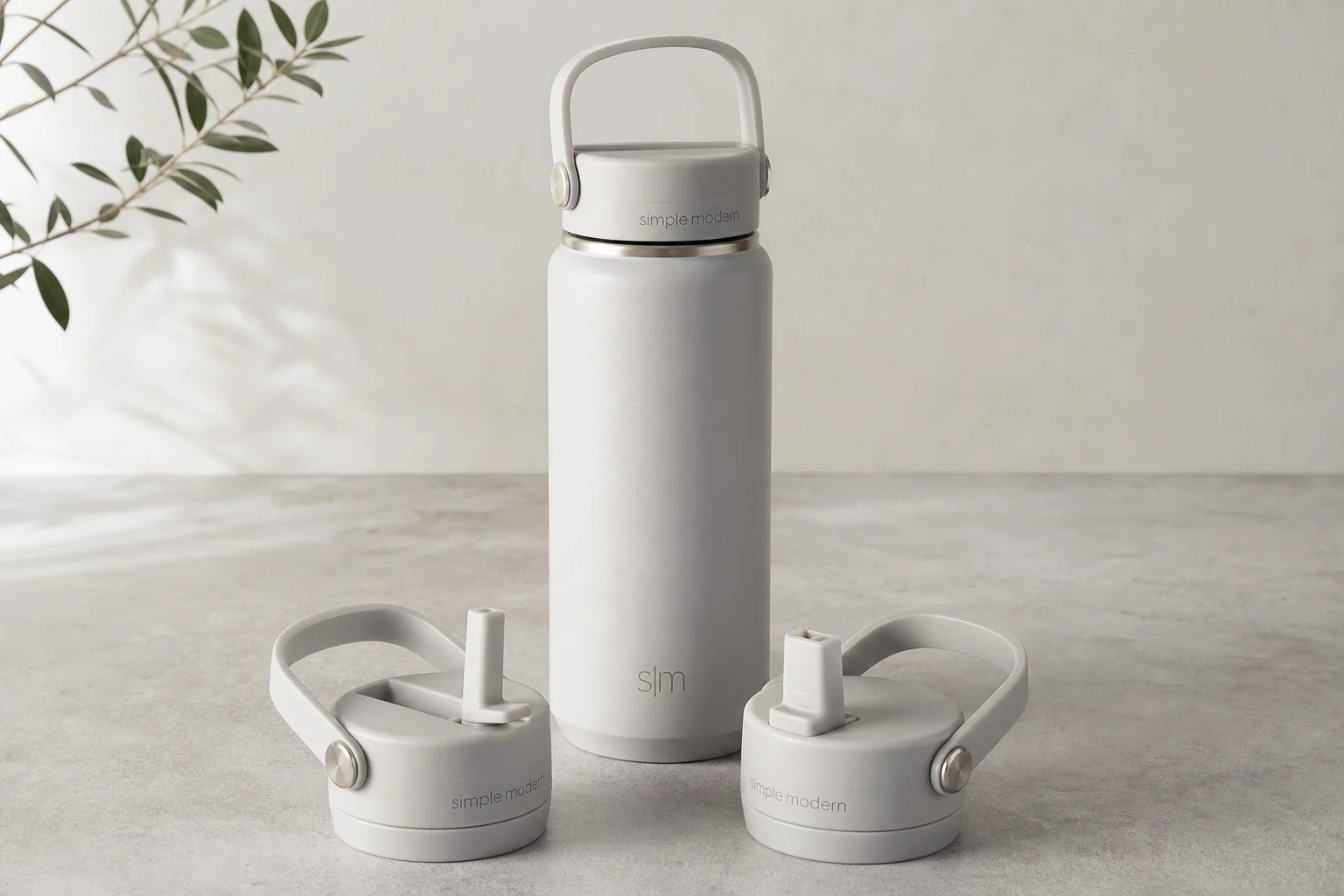 Collection of ten insulated bottles and travel mugs displayed on concrete surface