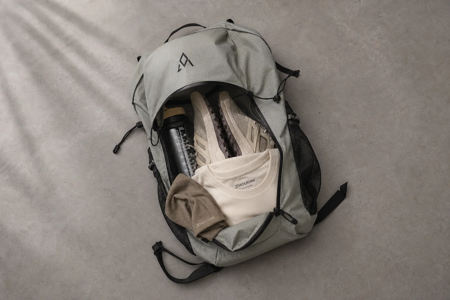 Lightweight day hiking pack with minimal gear on concrete surface