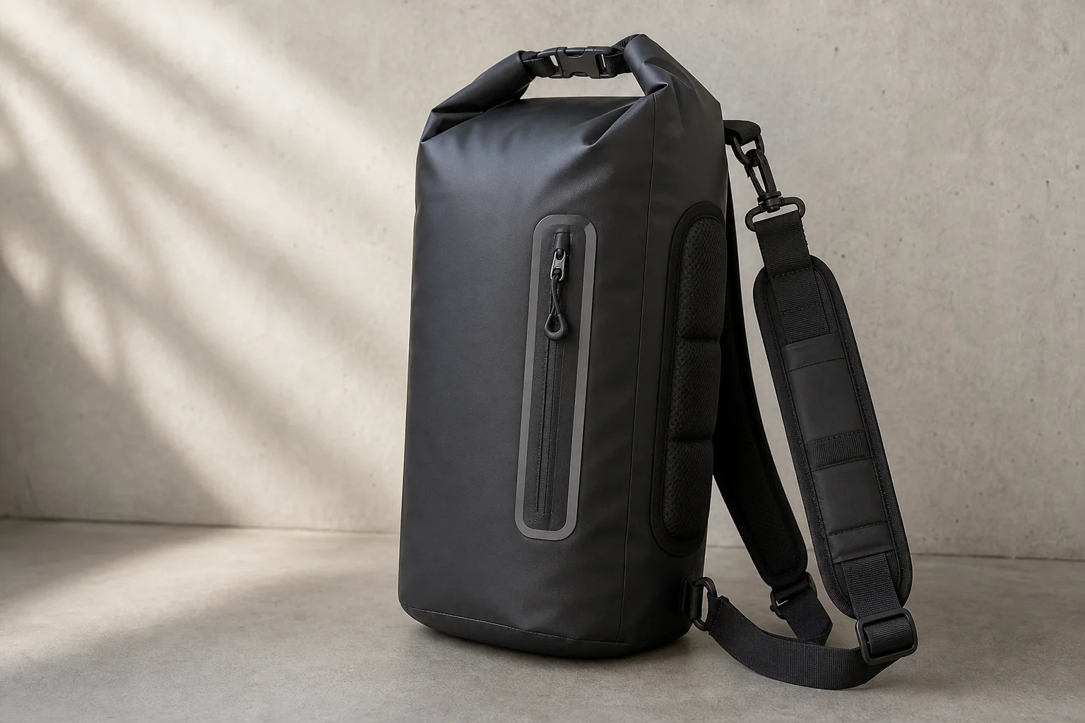 Five waterproof dry bags in various sizes and colors arranged on concrete