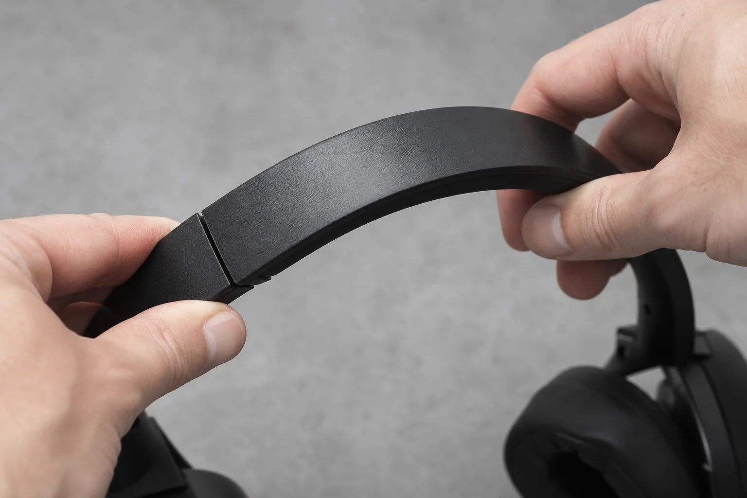 Close-up of headphone headband showing plastic construction and flexibility